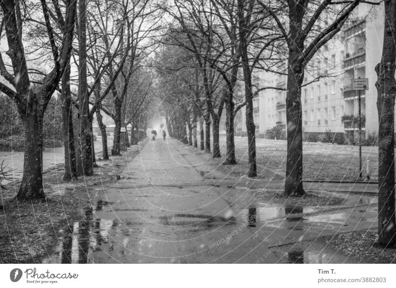 Winter in der Frankfurter Allee . Ein Naßkalter Bürgersteig . Berlin Straße Schwarzweißfoto Plattenbau Hauptstadt Außenaufnahme Schnee Frankfurter Tor Bauwerk