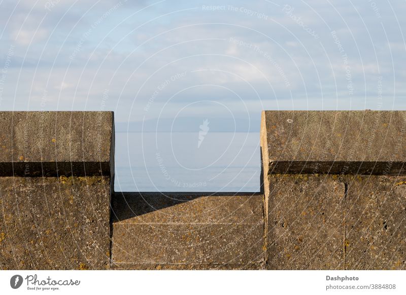 Brüstungsmauer am Strand an einem Küstenstandort Wand Stein Steine braun Algen Moos Schatten Konstruktion Architektur Mauerwerk Maurerhandwerk alt Ansicht