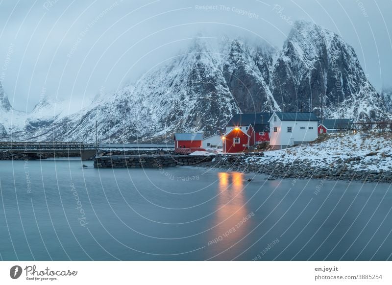 Rote und weiße Hütten in Reine auf den Lofoten zur blauen Stunde Norwegen Reinefjorden Skandinavien blaue Stunde Abendsonne Rorbuer Haus Häuserzeile Ferienhaus