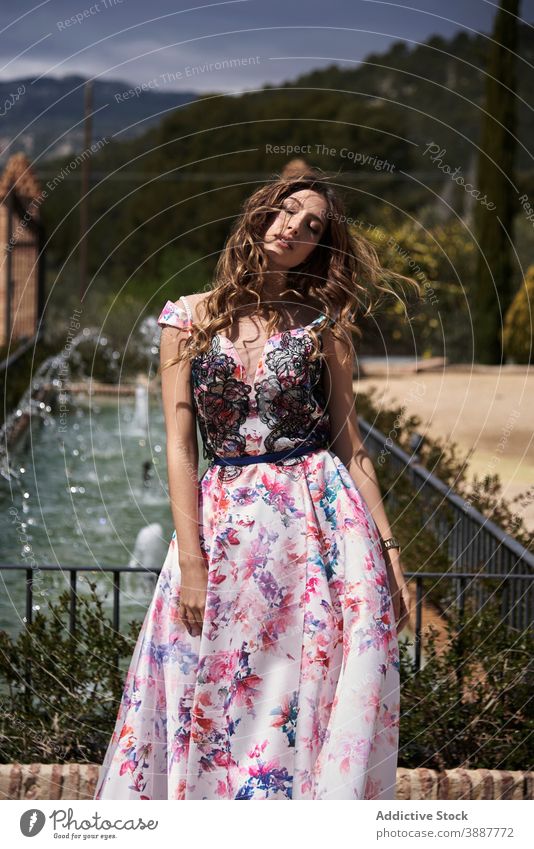 Anmutige Frau in langem Kleid im Park maxi elegant charmant Vorschein Schönheit langes Kleid Angebot Stil schick sich[Akk] entspannen jung Garten gewelltes Haar