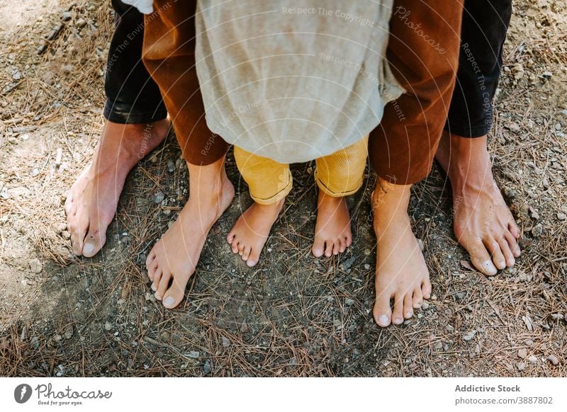 Familie Crop steht barfuß im Wald Einheit Hippie Zusammensein Barfuß Natur Bonden Paar Kind tagsüber Zuneigung sorgenfrei abstützen Vertrauen Partnerschaft