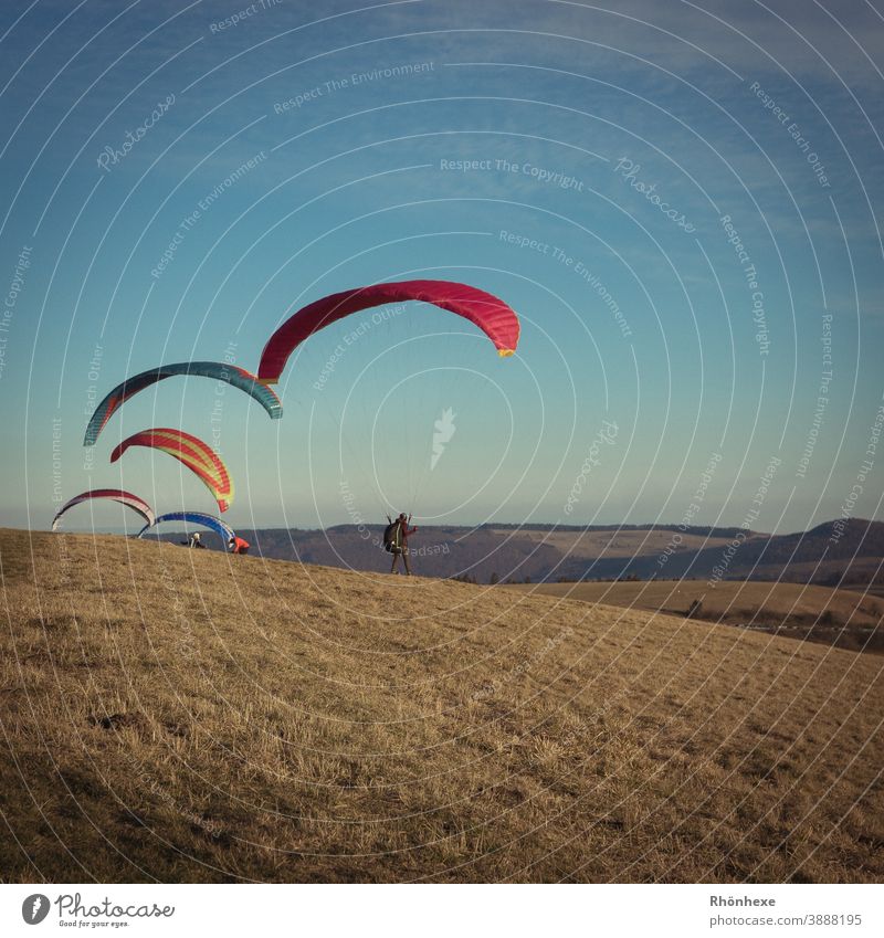 Gleitschirmflieger in der kalten Winterluft auf der Wasserkuppe fliegen Farbfoto Sport oben Himmel mehrfarbig Außenaufnahme Freizeit & Hobby Freiheit Tag