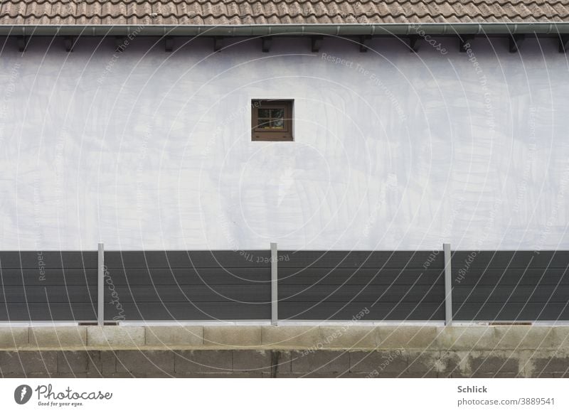 Sichtschutzzaun und winziges Fenster Zaun Fassade weiß hell klein Menschenleer Außenaufnahme Tag Haus Gebäude Wand Architektur trist Gedeckte Farben Dach