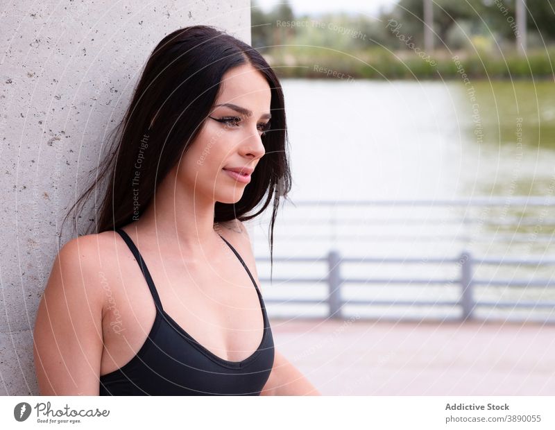 Fitte Frau ruht sich nach dem Training an der Wand aus passen schlank sportlich ruhen Stil trendy Lehnen besinnlich sich[Akk] entspannen Fitness jung brünett