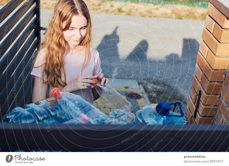 Junge Frau wirft leere gebrauchte Plastik-Wasserflaschen in den Mülleimer Behälter blau Flasche abholen sammelnd Container zerdrückt Entsorgung Ökologie Umwelt