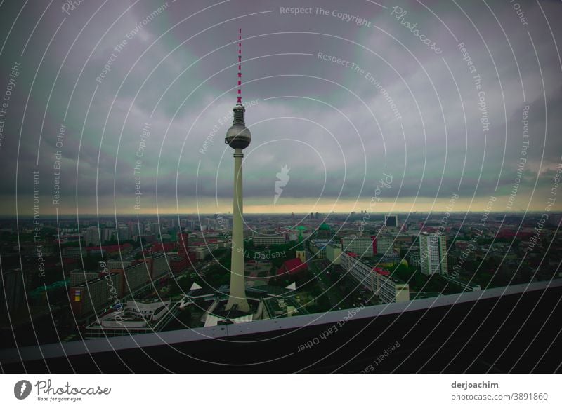 Wahrzeichen der Stadt. Berliner Fernsehturm am Spät - Nachmittag.  Dunkle Wolken bedecken den Himmel. Nur ein kleiner Streifen Helligkeit  am Horizont ist noch hell.