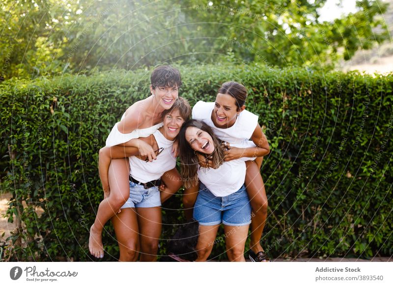 Gesellschaft von fröhlichen Frauen, die Spaß in der Stadt haben Huckepack Spaß haben Freundschaft Lachen Humor Bonden Großstadt Sommer Wochenende Zusammensein