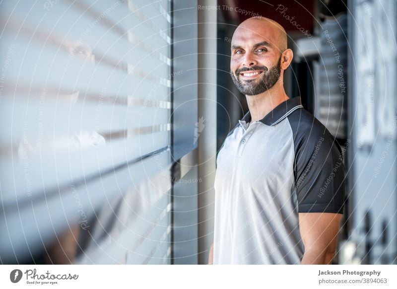 Porträt eines selbstbewussten, gut gebauten Mannes in der Turnhalle Trainerin Personal Fitnessstudio Lächeln Textfreiraum Bartiger Mann Vollbart Geschäftsmann