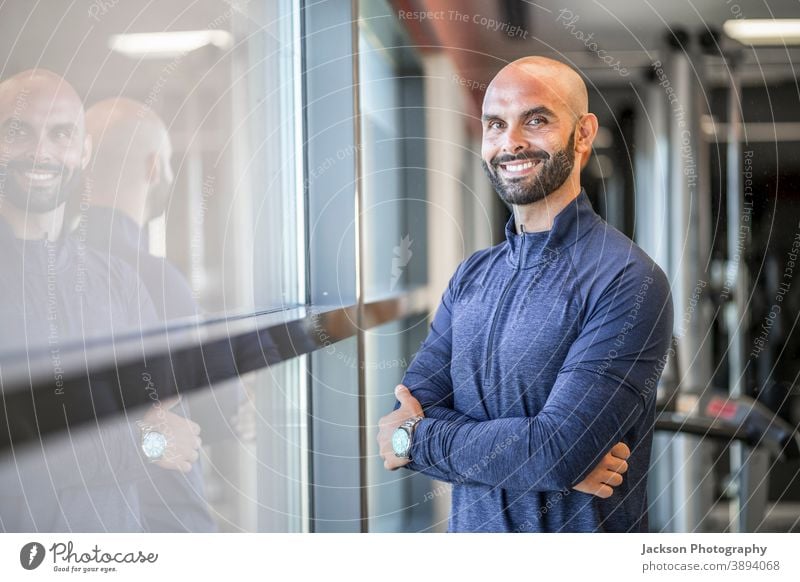 Porträt eines selbstbewussten, gut gebauten Mannes in der Turnhalle Trainerin Personal Fitnessstudio Lächeln Textfreiraum Bartiger Mann Vollbart Geschäftsmann