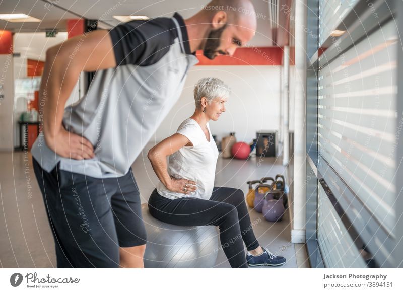 Schwangere Frau trainiert mit Personal Trainer schwanger Übung Fitnessstudio Trainerin Maschine trx Körperpflege Gewicht Unterleib Bauch im Innenbereich