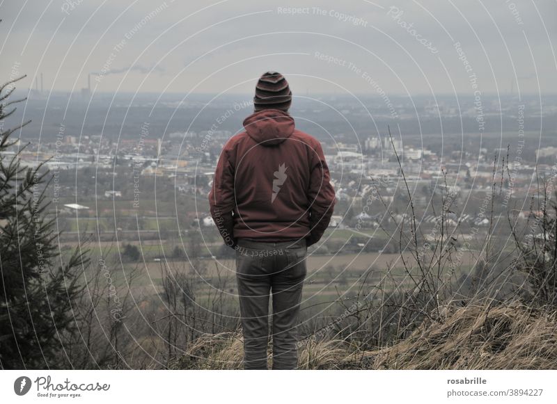 weit weg | ein Mann von hinten mit Blick in die Ferne ins Tal Hügel Berg Weite schauen Überblick trostlos Industrie Stadt Herbst trist hoffnungslos düster