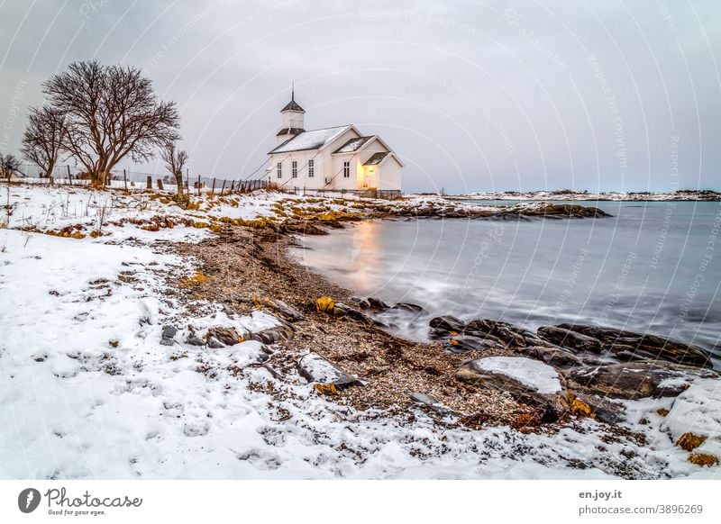 Gimsoy Kirche auf den Lofoten Gimsøy Strand Meer Bucht Schnee Winter Norwegen Skandinavien Baum Felsen Langzeitbelichtung Abend blaue Stunde Himmel Küste kalt