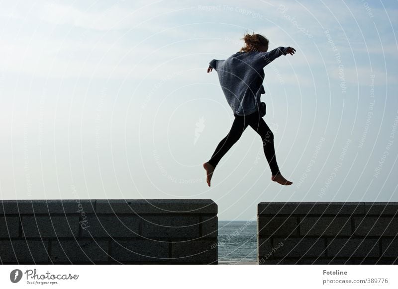 "Ich kann fliegen" ruft das Mädchen, breitet die Arme aus und springt über die Lücke in der Mauer Mensch feminin Kind Kindheit Körper Kopf Hand Finger Beine Fuß