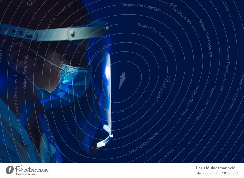 Ärztin mit Gesichtsschutz und Maske Seitenansicht auf dunkelblauem Hintergrund schwarzer Hintergrund Brasilien Korona-Epidemie Corona-Virus covid-19