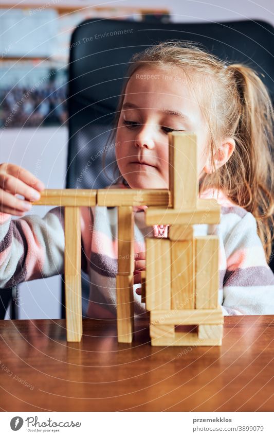 Kleines Mädchen im Vorschulalter spielt mit Holzklötzen Spielzeug, das ein Haus baut Aktivität Klotz Blöcke Baustein bauen Kind Kindheit Konzept Konstruktion