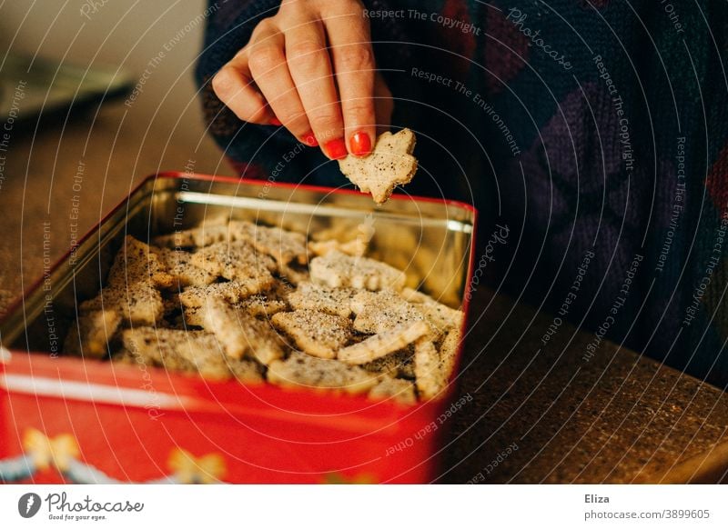 Frau nascht Weihnachtsplätzchen aus einer Plätzchendose naschen Weihnachten Weihnachtsnascherei Weihnachten & Advent Backwaren süß Keksdose Hand weiblich Mensch