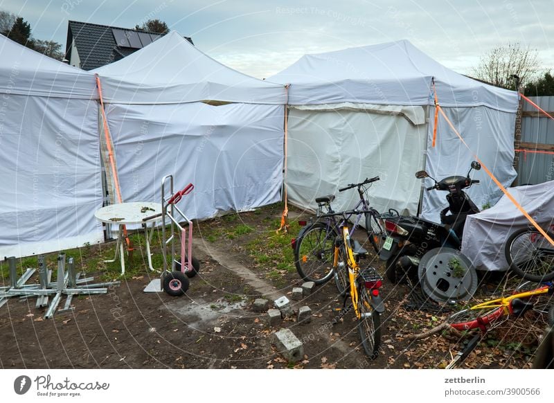 Abstellplatz für diverses Gerümpel zelt zeltplatz rad fahrrad parkplatz abstellplatzm lager hof hinterhof karre rad moped motorrad garten tisch müll sperrmüll