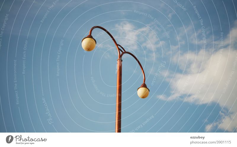 Straßenlampe Peitschenlaterne Lampe Straßenbeleuchtung Licht Himmel blau Laternenpfahl Wolken Tag Stadt Metall Großstadt Straßenlaterne Farbfoto leuchten