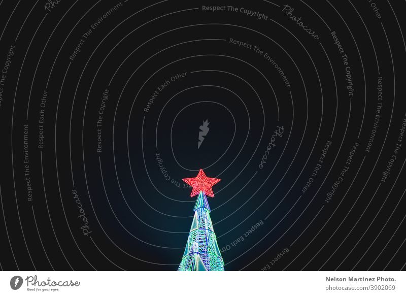 Roter Weihnachtsstern an der Spitze des Baumes, nachts mit Lichtern beleuchtet. Weihnachtsbaum Stern rot Feiertag Nacht Textfreiraum oben Weihnachten & Advent