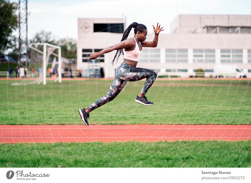 Afrikanisch-amerikanischer Athlet Sprinter springend entschlossen muskulös Afro-Look Amerikaner Beginn Ehrgeiz Motivation Bewegung dynamisch Training Übung