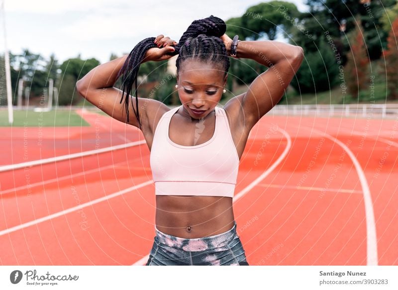 Athlet Sprinter berührt geflochtenes Haar Frau Bahn Leichtathletik Läufer rennen Konkurrenz passen Rennbahn Stadion Training Aktion sportlich Fitness Sport