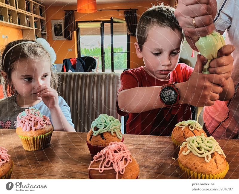 Kinder backen Muffins, bereiten Zutaten vor, dekorieren Kekse Cupcake dekorierend vorbereitend Essen zubereiten Familie heimisch Zusammensein Kindheit Glück