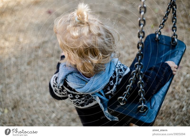 Kind mit Schaukel auf dem Spielplatz introvertiert waldorf Kinderkleidung Kindheit Spielen einsam traurig alleine zufrieden beobachten