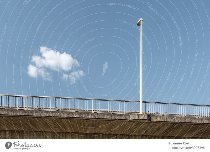 Laternenpfahl und Brückengeländer auf einer Brücke. Der Himmel ist blau, es gibt nur eine einzige Wolke. Geländer Architektur Tag Wolken Wolkenloser Himmel weiß