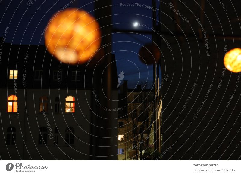 Leuchtende Lampions und leuchtende Fenster zwischen dunklen Häuserfronten in der Nacht mit Mond Licht Abendlicht Laterne Nachtleben Lampe Abendstimmung Energie