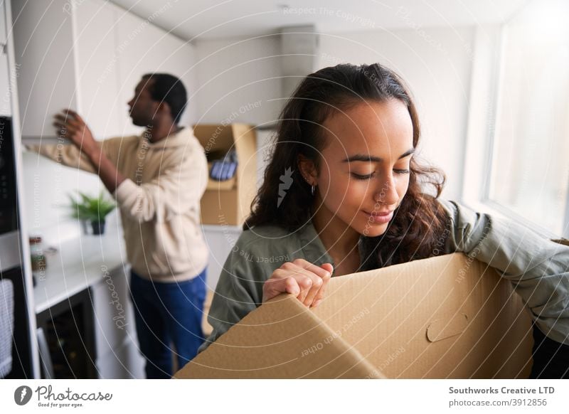 Aufgeregtes junges Paar in neuem Haus Auspacken Umzugskartons in der Küche zusammen Hauskauf Kisten heimwärts neues Zuhause erste Wohnung Einzug Umzugstag