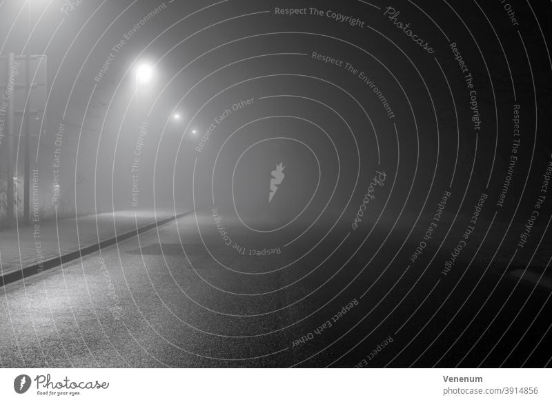 Nebel in den Straßen der Stadt Luckenwalde ,bei Nacht ohne Menschen neblig Lichtmast Peitschenlaterne Straßenleuchte beleuchtete Straßenlaterne Haus Häuser