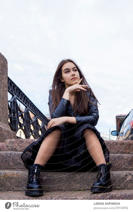 Porträt schöne junge Frau in eleganten schwarzen Kleid und Stiefel auf Stadtstraße. Positive Mode Dame im Freien Mädchen attraktiv Straße urban Sommer lässig