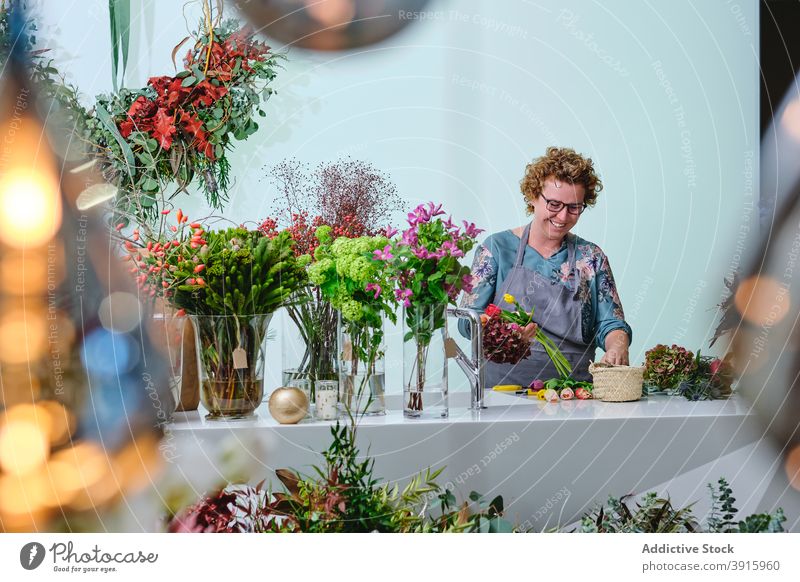 Florist erstellt Blumenstrauß im Salon Blumenhändler Frau Werkstatt Tulpe Haufen farbenfroh frisch Windstille Blütezeit Schürze Beruf Flora Verkäuferin