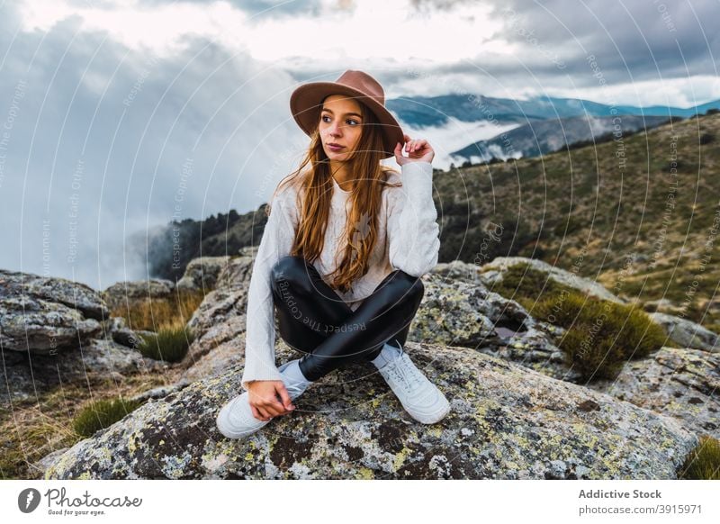 Frau mit Hut genießt den Blick auf die Berge Berge u. Gebirge beobachten Aussichtspunkt reisen Tourist Hochland bewundern erkunden Stein malerisch sitzen Natur