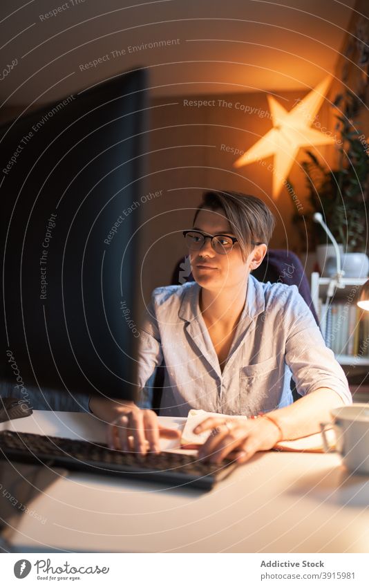 Intelligente Frau arbeitet am Computer im Büro zu Hause Unternehmer Arbeit heimwärts Projekt Monitor online dunkel Raum lässig Outfit Browsen Tisch