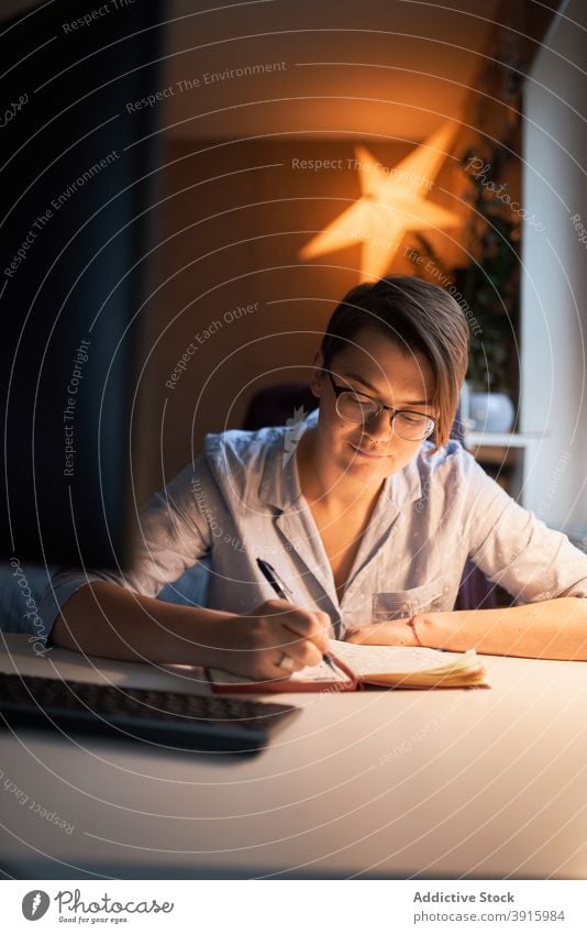 Intelligente Frau arbeitet am Computer im Büro zu Hause Unternehmer Arbeit heimwärts Projekt Monitor online dunkel Notizblock schreiben Raum lässig Outfit