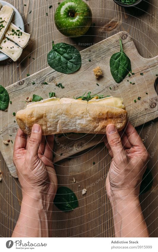 Hand hält ein Panini mit Brie-Käse und Apfel Mittagessen Brot Lebensmittel Snack Gesundheit Frühstück Mahlzeit Tomate Belegtes Brot frisch Zuprosten Abendessen