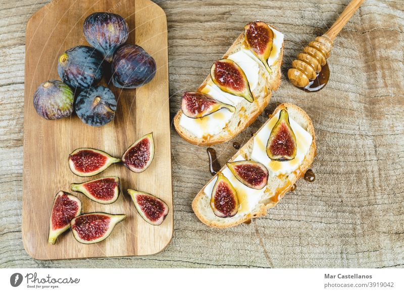 Feigen geschnitten auf Toast mit Käse. Zuprosten Brot Frühstück Snack reif Frucht ganz Küchentisch Holzboden Textfreiraum Draufsicht purpur geschmackvoll