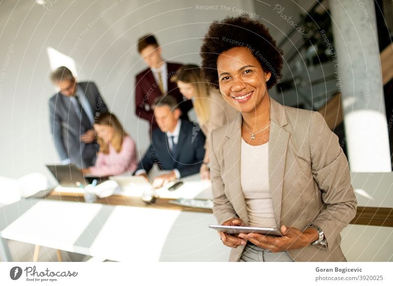 Afroamerikanische Geschäftsfrau stehend und mit digitalem Tablet in einem modernen Büro Erwachsener Afrikanisch Afro-Look Amerikaner schön schwarz Business