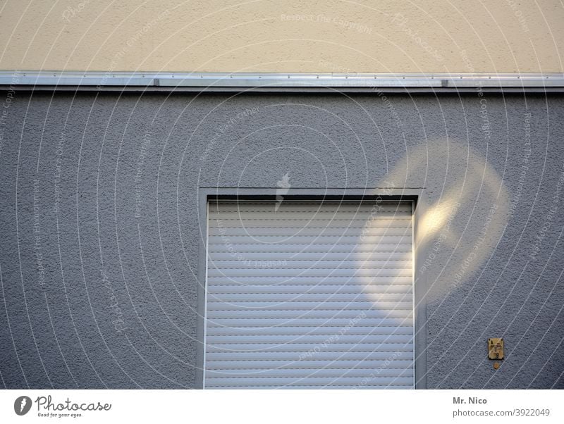 Fenster mit heruntergelassenem  Rolladen Fassade grau Rollo Mauer Bauwerk Gebäude Architektur Einfamilienhaus Haus Wohnung Nachbar Fensterplatz Fensterladen