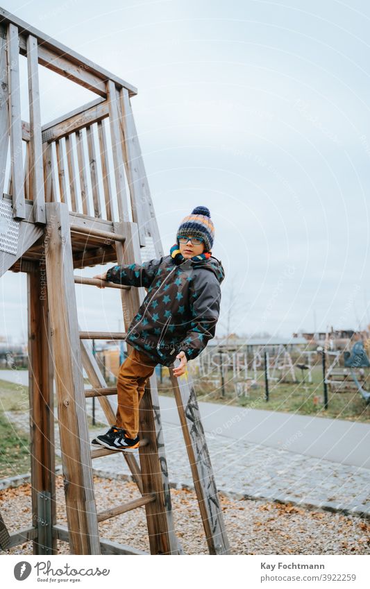 schwarzer Junge klettert auf Spielplatz Afroamerikaner Jungen sorgenfrei Freizeitkleidung Kind Kindheit Kinder Klettern kalt Dominanz Emotion Ausdruck Freiheit