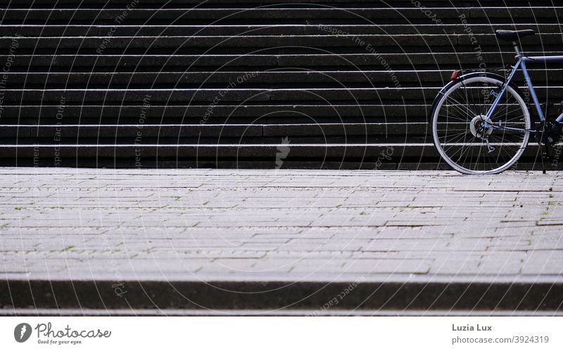 Stillstand oder der hintere Teil eines Fahrrads vor einer Treppe, Hinterrad platt Stufen Treppenstufen Platten Menschenleer aufwärts Außenaufnahme Treppenabsatz