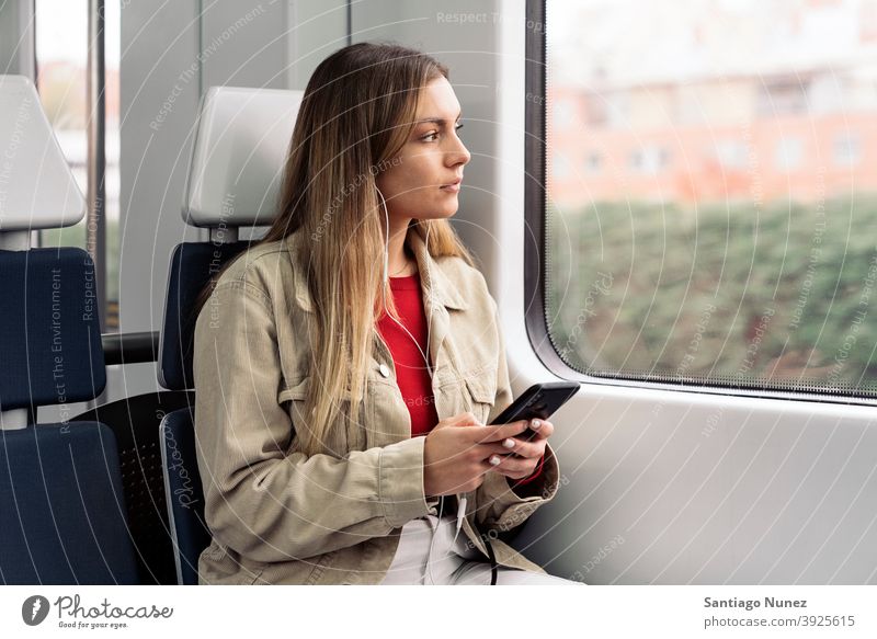 Blondes Mädchen im Zug reisend Kopfhörer Porträt jung 20s Vorderansicht blond hübsch Telefon per Telefon Funktelefon Kaukasier Blick Stehen Frau Smartphone