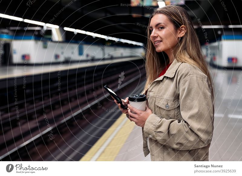 Junges Mädchen wartet auf dem Bahnsteig Seitenansicht Frau Kaukasier Porträt per Telefon Tippen Blick Hintergrund Stehen im Innenbereich im Freien U-Bahn