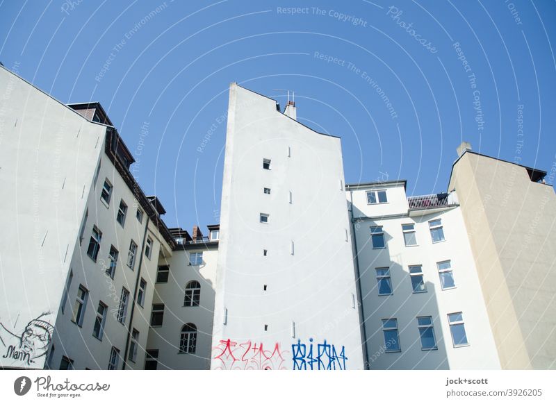 Öffnungen in außenliegender Brandwand Stadthaus Brandmauer Wolkenloser Himmel Fassade Hinterhof Symmetrie authentisch Architektur Graffiti Straßenkunst