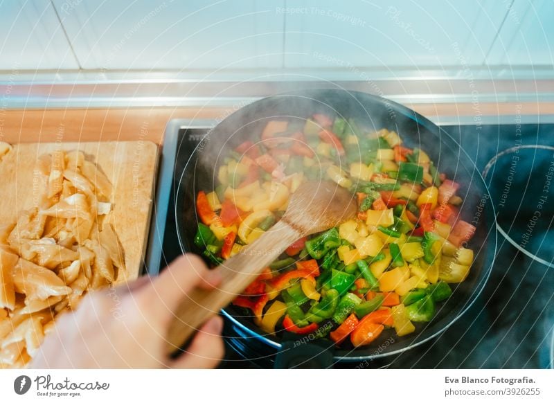 unerkennbar Frau bereitet Gemüse Essen in der Pfanne. Gesundes Essen Lebensmittel Küche Paprika farbenfroh Gesundheit rühren tiefstehend Möhre Kohlgewächse