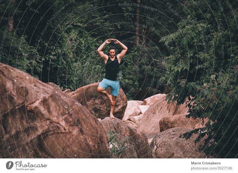 Eine Person, die eine Yogapose auf einem großen Felsbrocken im Preah Monivong National Park in Kampot, Kambodscha, einnimmt Pose Mann Felsblöcke kampot