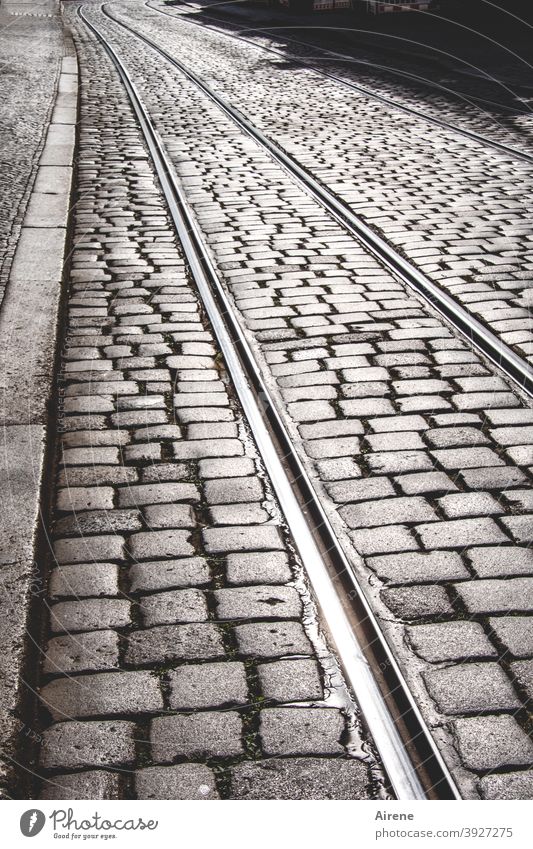 immer den Schienen nach Straße Kopfsteinpflaster Straßenbahnschienen geradeaus Zielgerade menschenleer grau gepflastert sonnig Fußgängerzone Pflastersteine