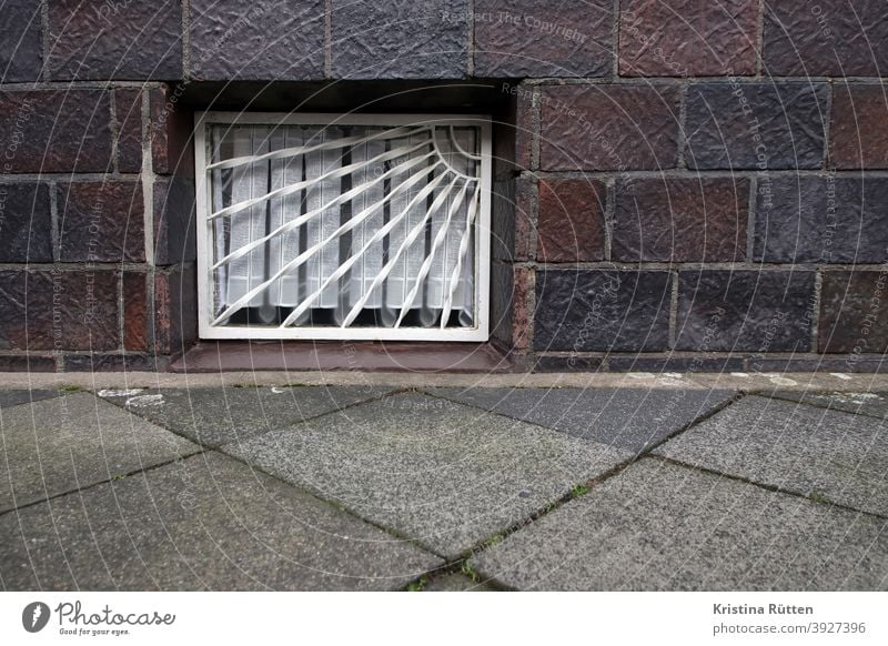 kellerfenster mit gitter fenstergitter vergittert gardine haus bürgersteig gehweg fassade architektur gebäude ansicht sichtschutz einbruchschutz sicherheit