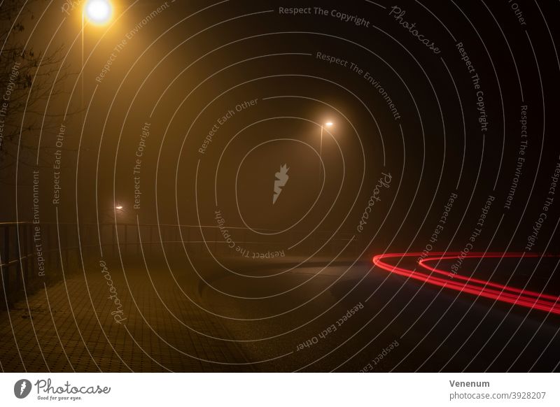 Lichtspuren von Autos im Nebel bei Nacht PKW Lastkraftwagen Scheinwerfer Straße Autobahn Baum Bäume Himmel Abend Blinker Rückleuchten rot weiß Wegweiser